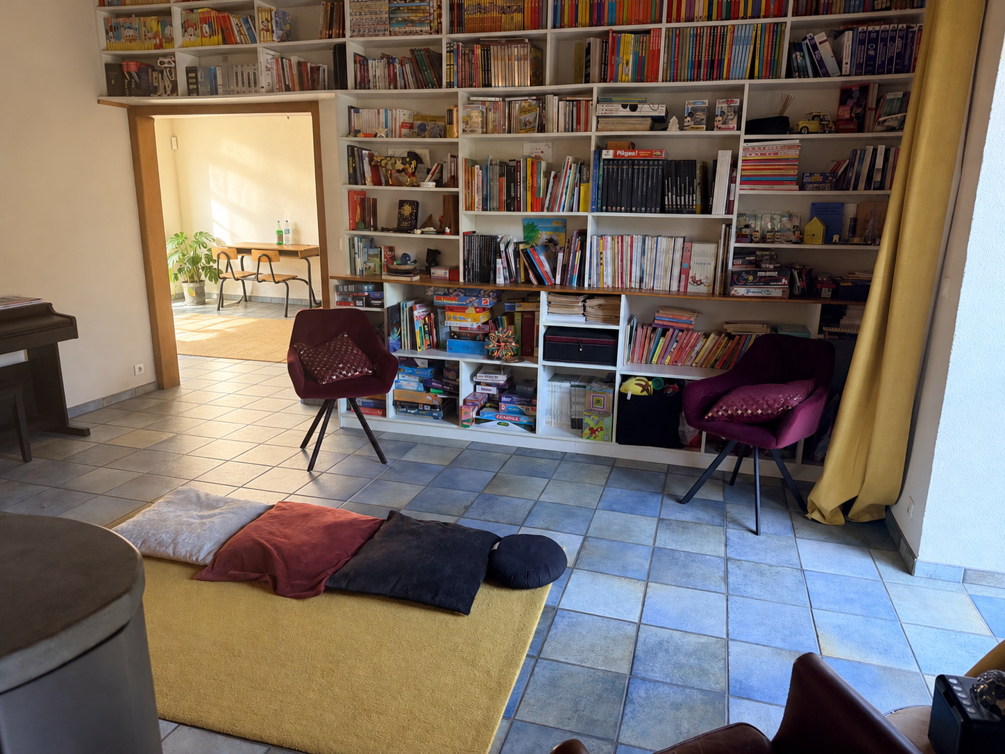 Coin bibliothèque près du poêle à bois, avec fauteuils, livres et espace de détente
