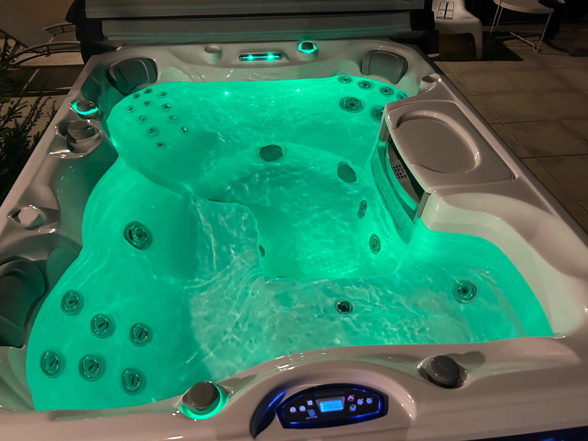 Jacuzzi illuminé en vert avec ses jets en fonctionnement